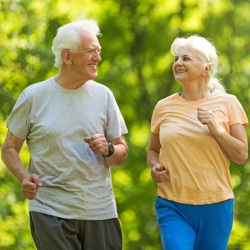 Senior couple running in park