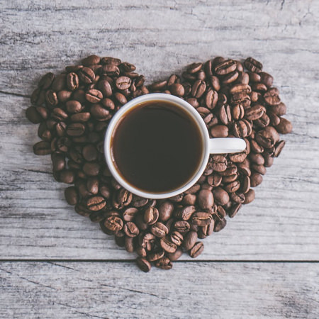 cup of Philly Fair Trade Coffee with beans shaped in a heart