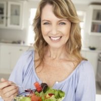 Healthy Woman Eating Delicious Leafy Greens and Berries Salad