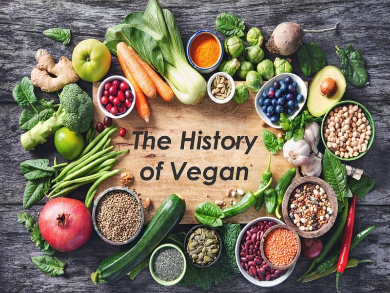 healthy vegan food selection on cutting board with the words the history of vegan