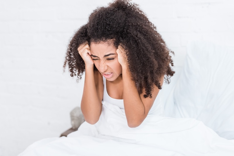 Woman in bed with migraine