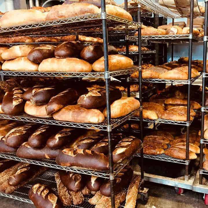 Racks of fresh baked bread from local bakery: Le Bus Bakery